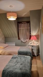 ein Schlafzimmer mit 2 Betten und einem Tisch mit einer Lampe in der Unterkunft Appartement Clos Mathilde in Cabourg