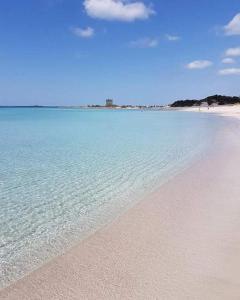 a beach with clear blue water and a sandy shore at Risa Apulia in Torre Lapillo