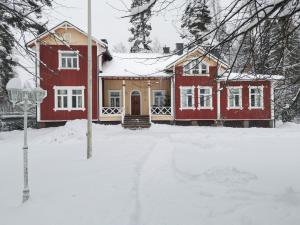 a red house in the snow with a yard at Inhan Kartano in Ähtäri