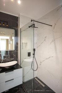 La salle de bains est pourvue d'un lavabo et d'une douche avec un miroir. dans l'établissement 18th Elite View by Tower Apartments, à Cluj-Napoca