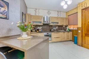 a kitchen with wooden cabinets and a vase of flowers on a counter at Charming 2BR home in the heart of Marsaxlokk by 360 Estates in Marsaxlokk