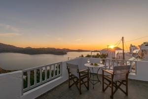 a balcony with a table and chairs and a view of the ocean at Sunset studio in Plaka in Plaka Milou