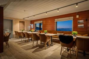 a dining room with tables and chairs and windows at Halne Fjellstugu in Maurset