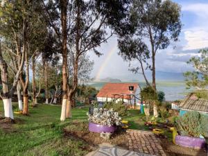 einen Regenbogen über einem Haus mit Garten in der Unterkunft Alojamiento en cabaña in Fúquene