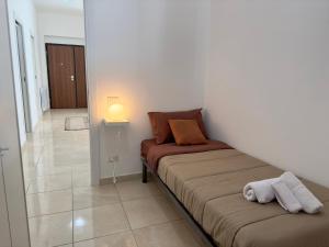 ein Bett in einem Zimmer mit einer Lampe und einem Zimmer in der Unterkunft 110 mq piano terra- Parcheggio privato-Giardino in Velletri