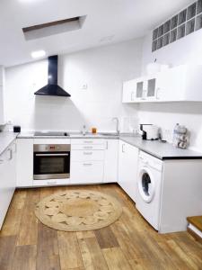 cocina con electrodomésticos blancos y suelo de madera en 2 bedrooms house with city view enclosed garden and wifi at Vila Nova de Santo Andre, en Giz
