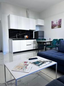 een woonkamer met een tafel en een keuken bij Prime Luxury Apartments in Lushnjë