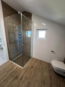 uma casa de banho com um chuveiro e um WC. em Penthouse SKY DELUXE em Novalja