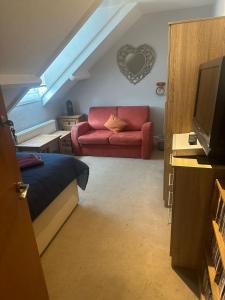 ein Wohnzimmer mit einem roten Sofa und einem TV in der Unterkunft OYO The Barley House in Plymouth