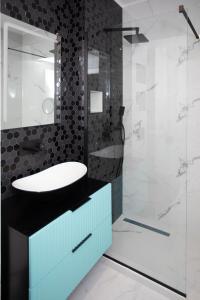 La salle de bains est pourvue d'un lavabo et d'une douche en verre. dans l'établissement 18th Elite View by Tower Apartments, à Cluj-Napoca