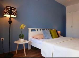 a bedroom with a bed and a table with a lamp at Apartments Lungo Mare Ulcinj in Ulcinj