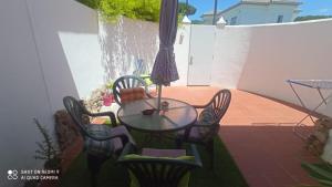 a table with chairs and an umbrella on a patio at Apartamento Ambar in Novo Sancti Petri