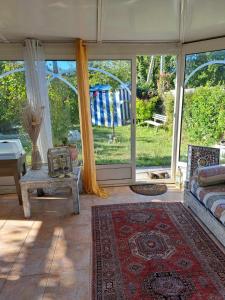 a living room with a couch and a large window at La maison de Caroline in La Rochelle