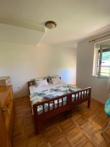 a bedroom with a bed and a window at Apartments TEA in Trebinje