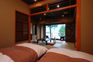 a bedroom with two beds and a view of a patio at Rakuyu in Fujikawaguchiko