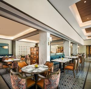a restaurant with tables and chairs in a room at Ekante Bliss Tirupati - IHCL SeleQtions in Tirupati
