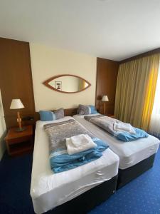 um quarto de hotel com duas camas e um espelho em Hotel Regina em Sankt Augustin