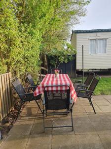 einem Tisch mit einem roten und weißen karierten Tischtuch in der Unterkunft Dog Friendly 8 Berth Caravan At Dovercourt Holiday Park In Essex Ref 44004p in Great Oakley