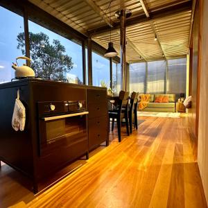 a kitchen with a stove and a table with chairs at Clareira Cabanas in Gonçalves