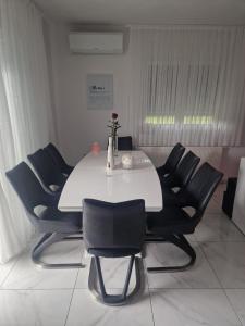 uma mesa branca com cadeiras pretas num quarto em Villa Ema em Zagreb