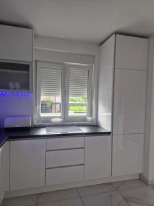 uma cozinha com armários brancos e uma janela em Villa Ema em Zagreb