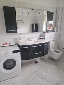 a bathroom with a washing machine and a toilet at Villa Ema in Zagreb