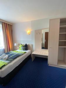 una camera d'albergo con letto e specchio di Hotel Regina a Sankt Augustin