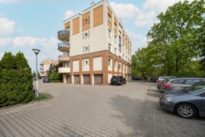 un bâtiment avec des voitures garées dans un parking dans l'établissement Beautiful Apartment in Wrocław for 4 people by Rent like home, à Wrocław
