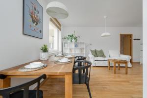 - une salle à manger et un salon avec une table et des chaises dans l'établissement Beautiful Apartment in Wrocław for 4 people by Rent like home, à Wrocław