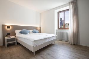 um quarto branco com uma cama e uma janela em Villa Stanga - Gardaslowemotion em Tenno