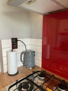a kitchen counter with a stove and a tea kettle at Top Floor 1 Bedroom Apartment with views over London in London