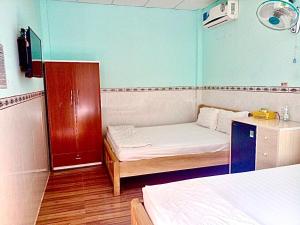 um pequeno quarto com uma cama e uma secretária em NHÀ NGHỈ LONG VIÊN em Hàm Tân