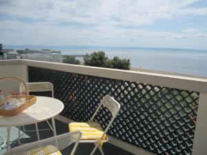 een balkon met een tafel en stoelen en de oceaan bij Appartamento Miramar in Grado-Pineta