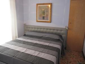 een bed in een kamer met een foto aan de muur bij Appartamento Miramar in Grado-Pineta
