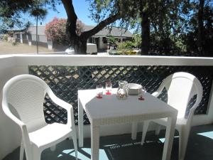 een witte tafel en 2 stoelen op een patio bij Appartamento Miramar in Grado-Pineta
