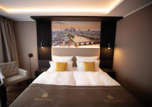 a hotel room with a large bed with a painting on the wall at Skyline Hotel City Frankfurt in Frankfurt
