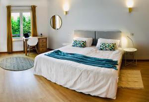 a bedroom with a large white bed and a desk at Casa Maria Vera in Lagos +21 photos