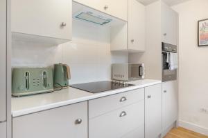 a kitchen with white cabinets and a green appliance at Feels like Home, 4-Bedroom in Stanley, Sleeps 7 in Stanley