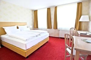 ein Hotelzimmer mit einem Bett und einem Schreibtisch in der Unterkunft Parkhotel Wörlitz in Oranienbaum-Wörlitz