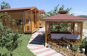 a wooden house with a gazebo in the yard at Şahan Bungalov in Gökçe
