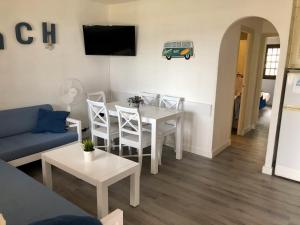 a living room with a couch and a table and chairs at Apartamento el Descanso in Son Bou
