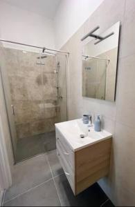 La salle de bains est pourvue d'un lavabo et d'une douche avec un miroir. dans l'établissement New Stylish & Modern Studio Apart - with sea view, à Pula