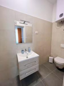 La salle de bains blanche est pourvue d'un lavabo et de toilettes. dans l'établissement New Stylish & Modern Studio Apart - with sea view, à Pula