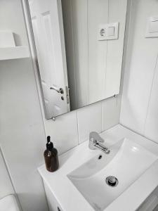 Baño blanco con lavabo y espejo en Habitación Callao, en Madrid
