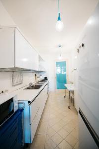 eine Küche mit weißen Schränken und einer blauen Tür in der Unterkunft Taormina Chic Apartment in Taormina