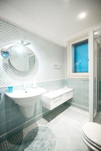 ein Badezimmer mit einem Waschbecken, einem WC und einem Spiegel in der Unterkunft Taormina Chic Apartment in Taormina