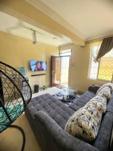 a living room with a couch and a tv at Paradise Apartments in Kilifi