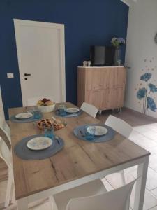 a dining room table with plates and bowls on it at Ranieli Apartments in Drapia