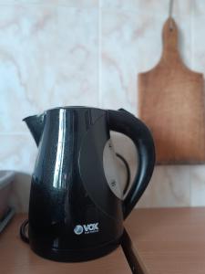 a black coffee pot sitting on top of a table at Stella Apartment in Karaburma