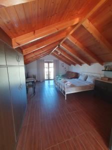 Cette grande chambre dispose d'un lit et de plafonds en bois. dans l'établissement LittleLoft Ioannina, à Ioannina